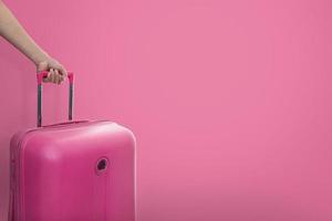 hand met roze koffer foto