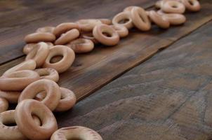 een veel van vers geel bagels liggen Aan de oppervlakte van de oud donker hout. een populair soort van meel producten. een van de traditioneel Russisch behandelt voor thee foto