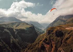 persoon paragliden over bergen foto