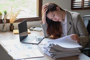 concept burn-out syndroom. zakenvrouw voelt zich ongemakkelijk bij het werken. die wordt veroorzaakt door stress, opgebouwd door onsuccesvol werk en minder rustend lichaam. raadpleeg een gespecialiseerde psychiater. foto