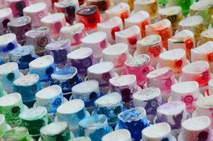 een patroon van een veel mondstukken van een verf sproeier voor tekening graffiti, besmeurd in verschillend kleuren. de plastic petten zijn geregeld in veel rijen vormen de kleur van de regenboog foto