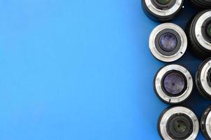 meerdere fotografisch lenzen liggen Aan een helder blauw achtergrond. ruimte voor tekst foto