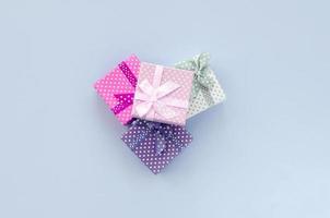 stapel van een klein gekleurde geschenk dozen met linten leugens Aan een paars achtergrond foto