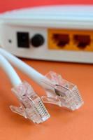 internet router en internet kabel pluggen liggen Aan een helder oranje achtergrond. items verplicht voor internet verbinding foto