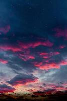 sterren en rode wolken bij zonsondergang