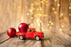 miniatuur auto Aan houten achtergrond met Kerstmis licht. foto