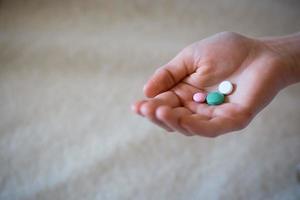 vrouw Holding een pil in haar hand, behandeling van verkoudheid. foto