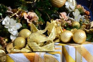 foto van luxe geschenk dozen onder Kerstmis boom, nieuw jaar huis decoraties, gouden omhulsel van de kerstman presenteert, feestelijk Spar boom versierd met guirlande, kerstballen en speelgoed, traditioneel viering