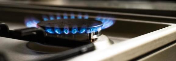 detailopname van een blauw brand van een keuken fornuis. twee gas- branders met een brandend vlam. economie concept.breed baner foto