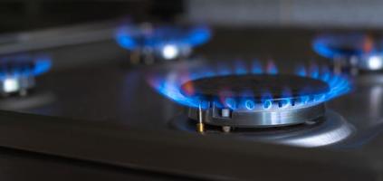 detailopname van een blauw brand van een keuken fornuis. 4 gas- branders met een brandend vlam. economie concept. breed banier foto