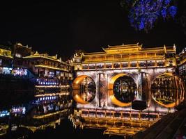 landschap visie van hong brug en gebouw in de nacht van fenghuang oud stad- .Feniks oude stad- of fenghuang provincie is een provincie van hunan provincie, China foto