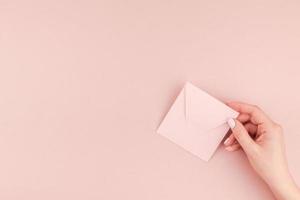 vrouw hand- Holding klein roze liefde brief foto