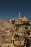 visie Bij oud gebouwen, muren, daken en rots met religieus kruis in oude dorp, sassi de matera, Italië. foto