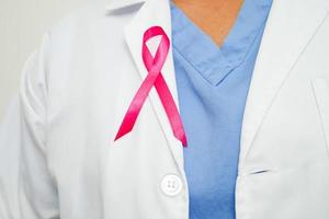 Aziatisch vrouw dokter met roze lint, wereld borst kanker dag Bij oktober. foto