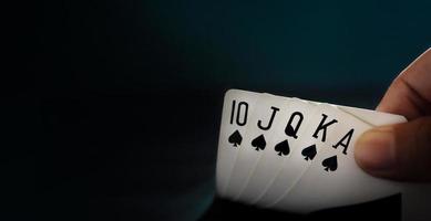 Koninklijk staat doorspoelen spelen kaart. speler opening een poker kaart. detailopname en donker toon foto