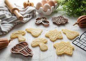 koekjes vormig Leuk vinden pompoen en bladeren Aan rustiek hout achtergrond foto