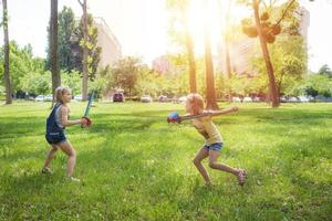 twee meisjes spelen met Zwaarden in de park. foto