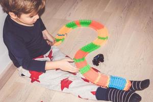 klein jongen maken trails voor auto speelgoed Aan de vloer. foto