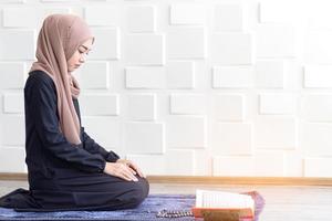 moslimvrouwen gekleed in zwarte hijab, biddend