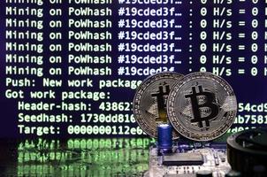 twee bitcoins leugens Aan een videokaart oppervlakte met achtergrond van scherm Scherm van cryptogeld mijnbouw door gebruik makend van de gpu's foto