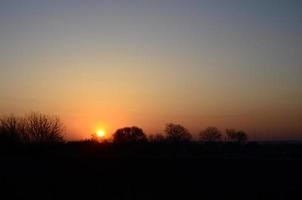 dageraad in de dorp. zonsopkomst in de buitenwijk landschap foto