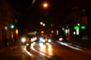 wazig nacht tafereel van verkeer Aan de rijweg. onscherp beeld van auto's op reis met lichtgevend koplampen. bokeh kunst foto