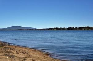 rivier- bank met water golven met berg visie achtergrond. foto