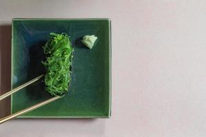 Japans voedsel zeewier sushi Aan bord heeft eetstokjes Aan bruin achtergrond. foto