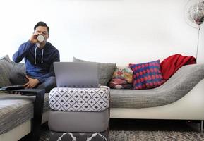 Mens werken van huis met een laptop in de leven kamer foto