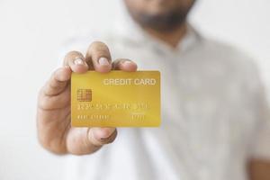 detailopname hand- van Aziatisch Mens Holding geel goud credit kaart in zijn hand. geïsoleerd Aan wit achtergrond. concept van financiën, handel, communicatie, sociaal, technologie, bedrijf foto