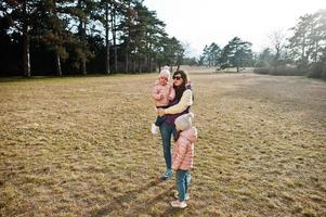 moeder met twee babymeisjes in valtice park, tsjechische republiek. foto