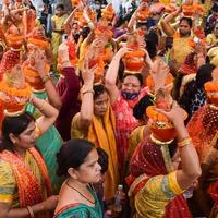 new delhi, india, 03 april 2022 - vrouwen met kalash op hoofd tijdens jagannath tempel mangal kalash yatra, indische hindoe toegewijden dragen aarden potten met heilig water met een kokosnoot erop foto