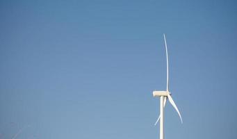 windturbine die elektriciteit opwekt over blauwe hemelachtergrond