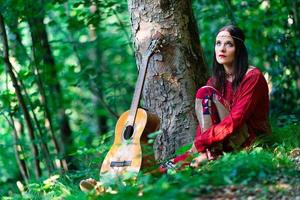 hippie meisje met de gitaar in de bossen foto