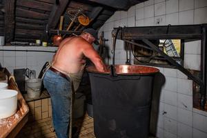 binnen een typisch alpine hut in noordelijk Italië de voorbereiding van kaas foto