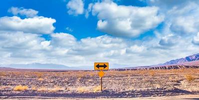 directionele teken in de woestijn met schilderachtige blauwe lucht en brede horizon. concept voor reis, vrijheid en transport. foto