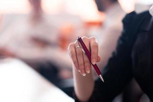 vrouw handen Holding pen Aan bedrijf vergadering foto