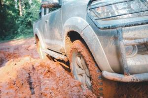 van de weg af banden, vuil van de weg af auto, suv gedekt met modder Aan platteland weg. van de weg af reizen en het rijden concept. foto