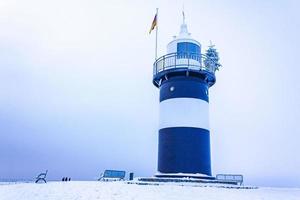 licht huis Bij bevroren dijk sneeuw ijs ijsschotsen glaasje ijs. foto