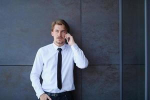 opstarten zakenman in een wit overhemd met een stropdas gebruik makend van mobiel telefoon foto