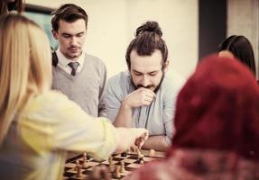 multi-etnisch groep van bedrijf mensen spelen schaak foto