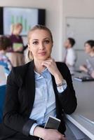 portret van jong bedrijf vrouw Bij kantoor met team Aan vergadering in achtergrond foto