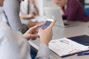 dichtbij omhoog van zakenvrouw handen gebruik makend van slim telefoon Aan vergadering foto