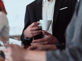 macro foto van een zakenman in een cafe in een pak Holding een kop van koffie.