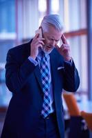 senior bedrijf Mens praten Aan mobiel telefoon foto