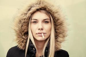 portret van jong blond meisje met sigaret in de mond foto