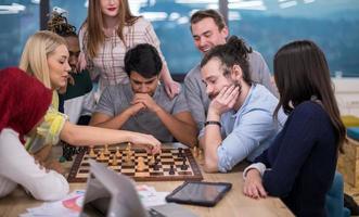 multi-etnisch groep van bedrijf mensen spelen schaak foto