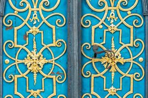 blauwe deur versierd met gouden versiering en handvat