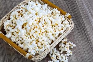 popcorn in een mand op houten achtergrond foto