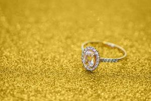 sieraden diamant ring met abstract feestelijk goud schitteren Kerstmis vakantie structuur achtergrond vervagen met bokeh licht foto